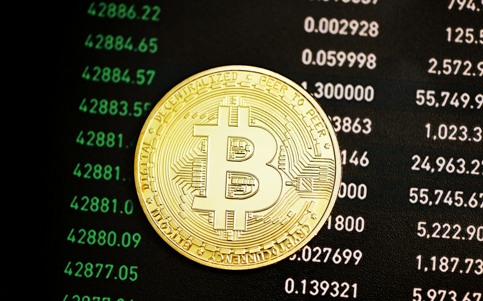 a bit coin sitting on top of a computer screen