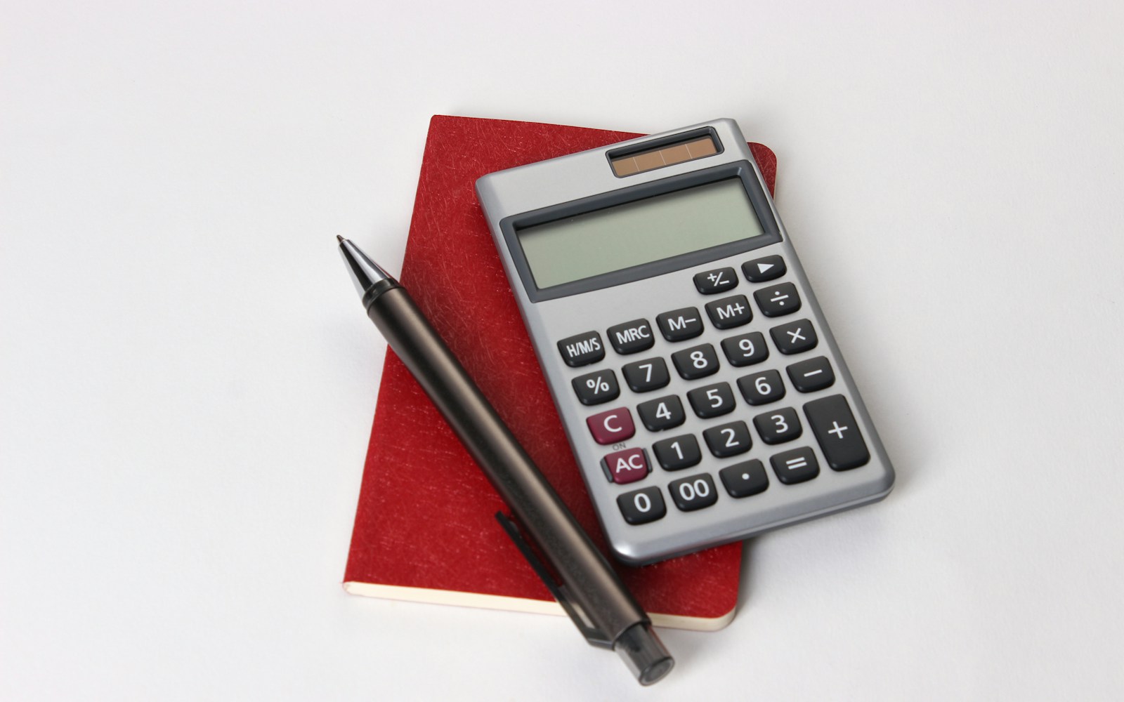 black and silver calculator beside black pen