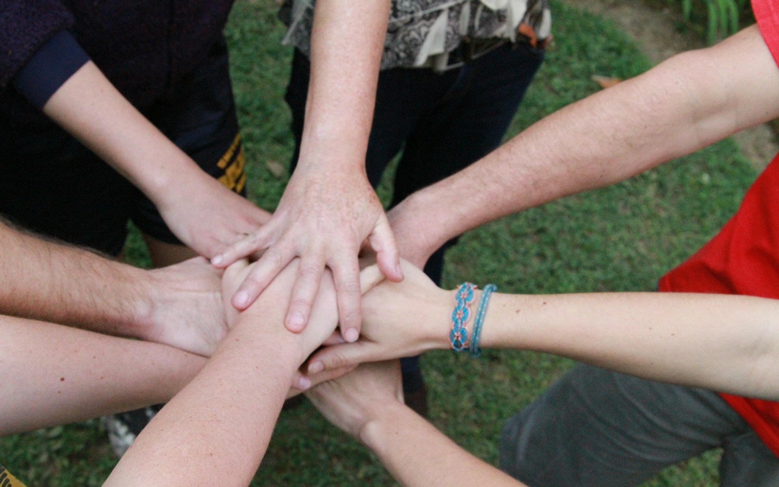 a group of people putting their hands together