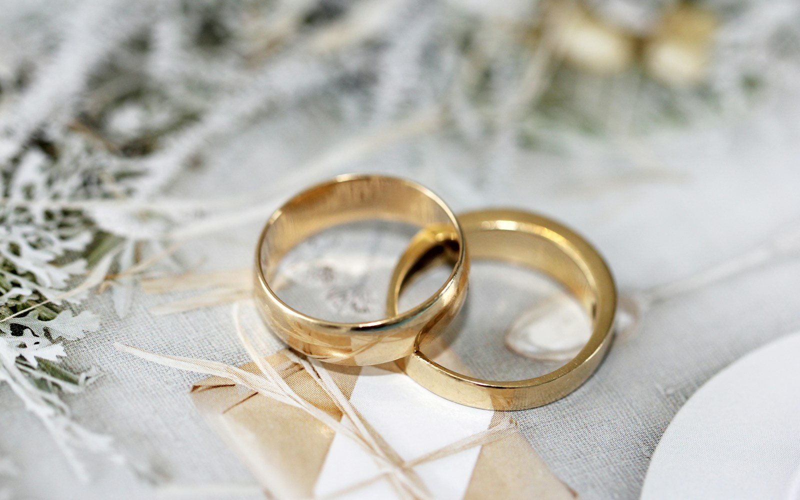 gold wedding band on white textile